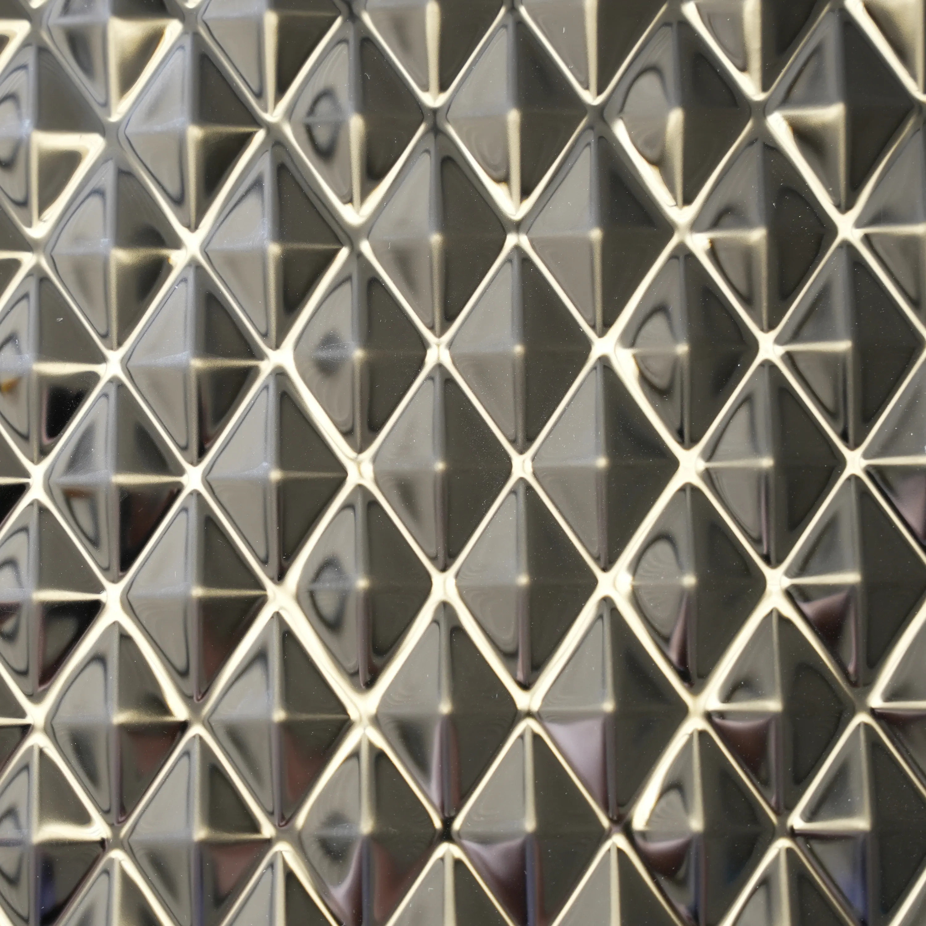 Glacial Diamond H3D pattern: tight diagonal grid of small four-sided pyramids on mirror silver stainless steel, sharp ridges catching light